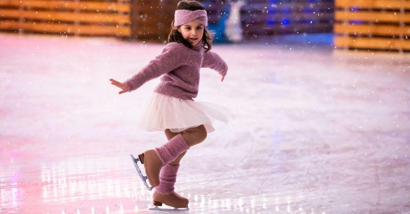 Fiatal lány élvezi a korcsolyázást a jégen