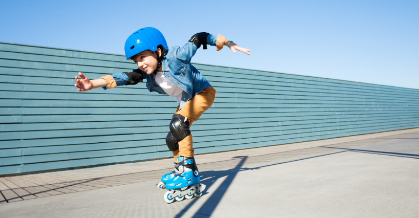 Gyerek kék sisakban és görkorcsolyában száguld a betonon