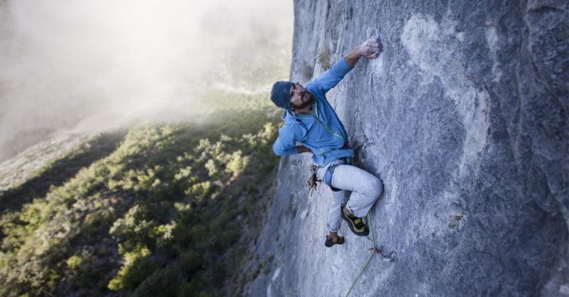 Mászó egy sziklafalon mászik felszereléssel